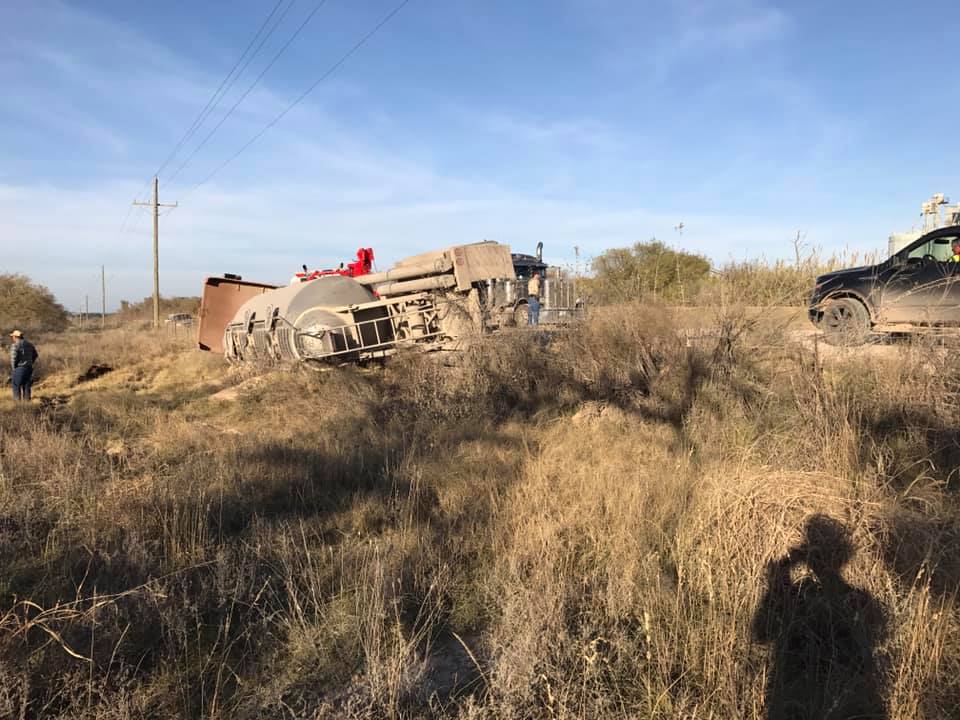 Recovery crew working an overturned commercial truck in a Central Texas field